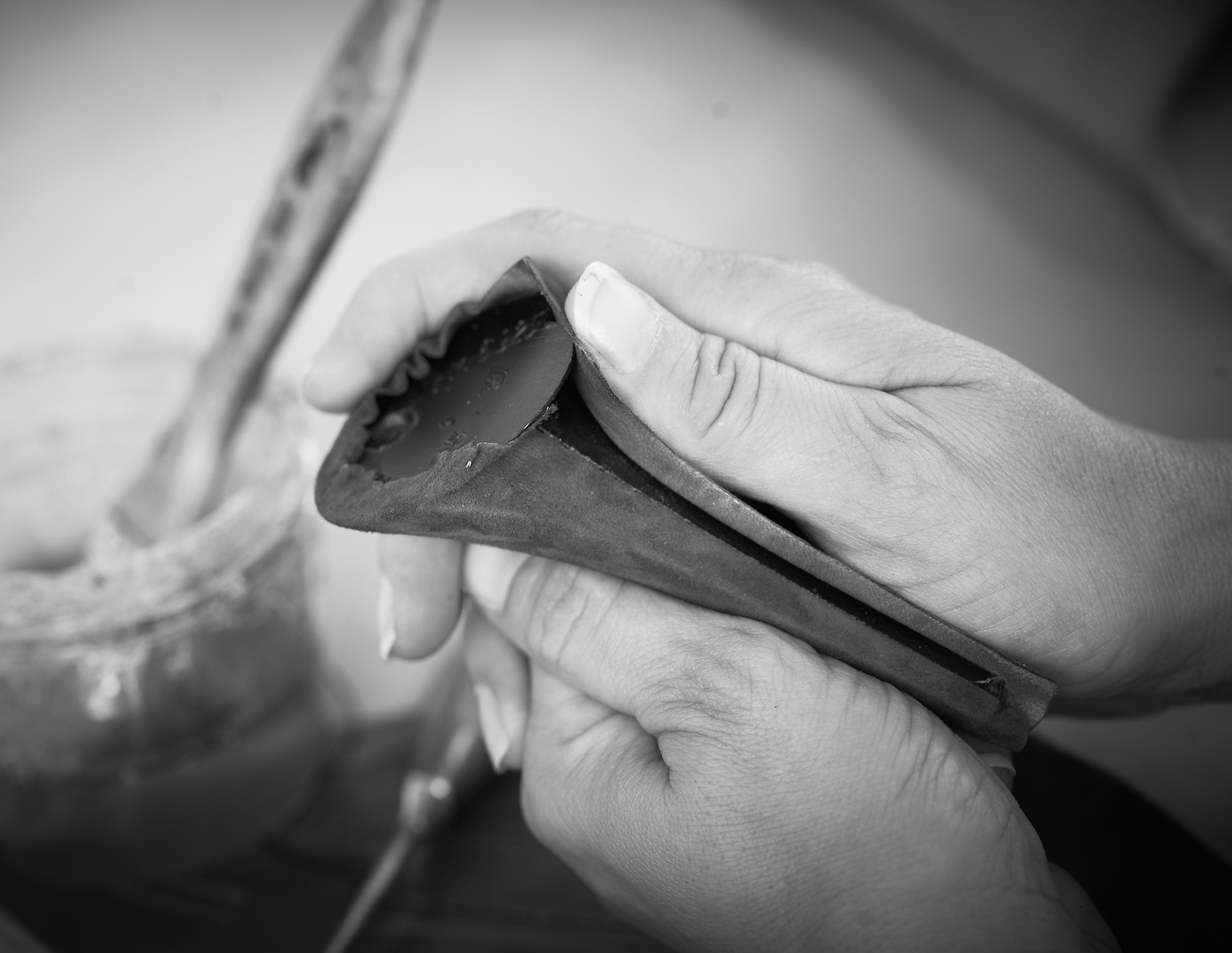 Encollage à la main d'une tige de chaussure en cuir, photo d'atelier en noir et blanc